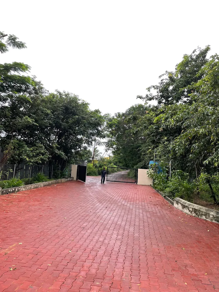 Gated entrance with brick driveway and trees